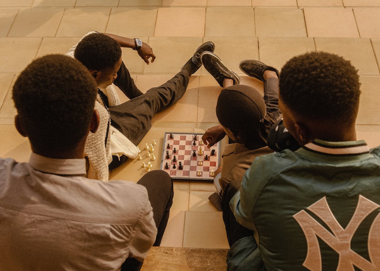 services-01 A group of youth engaging in a chess game outdoors in Ado Ekiti, Nigeria.