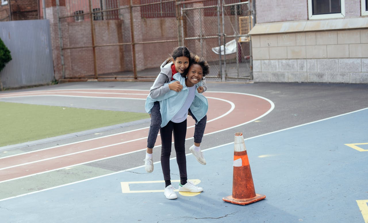 Crafting Captivating Headlines: Your awesome post title goes here Full body of positive diverse schoolgirls in sportswear doing piggyback ride on sports ground during training and looking at camera